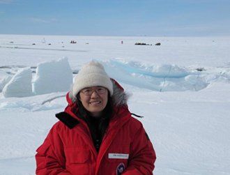 A woman in winter clothes surrounded by snow